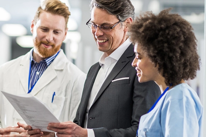 Three medical professionals looking at a report