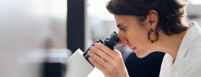 Woman looking into microscope